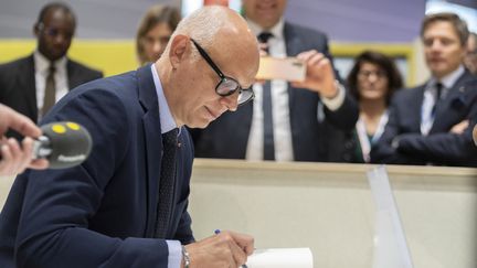 L'ancien Premier ministre Edouard Philippe signe son livre lors du 105e congrès de l'Association des maires de France. (SERGE TENANI / HANS LUCAS / VIA AFP)