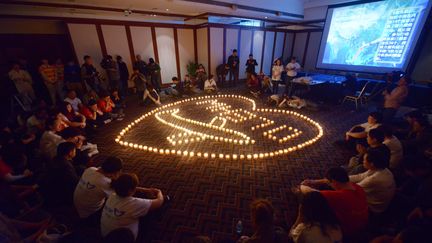 Des familles des passagers chinois du vol MH370 de Malaysia Airlines, disparu d&eacute;but mars 2014, prient dans un h&ocirc;tel de P&eacute;kin (Chine), le 8 avril 2014. (WANG ZHAO / AFP)