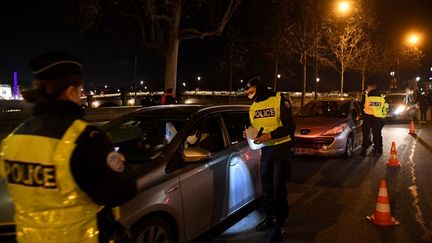 Des policiers vérifient les autorisations de déplacement des conducteurs à Paris, lors du couvre-feu, le 15 décembre 2020. (ALAIN JOCARD / AFP)