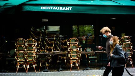 Deux personnes devant un bar fermé à Paris, le 21 octobre 2020.&nbsp; (EDOUARD RICHARD / HANS LUCAS)