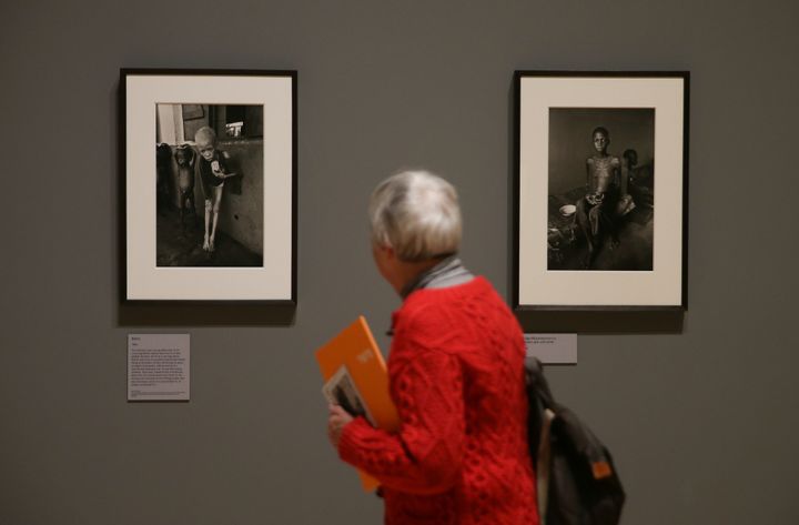 Un visiteur regarde deux photographies prises au Biafra en 1968 par Don McCullin. 
 (Daniel LEAL-OLIVAS / AFP)