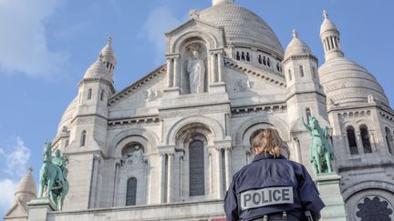 Une policière surveille les abords de la basilique du&nbsp;Sacré-Coeur&nbsp;à Paris, le 18 mars 2020.&nbsp; (AMAURY BLIN / HANS LUCAS)