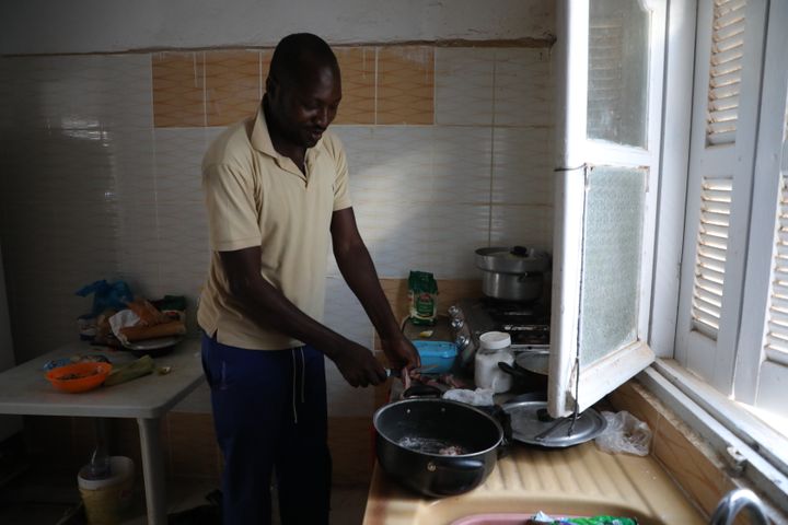 Christian prépare un bœuf sauce arachide, une recette camerounaise, dans la cuisine de son logement à Sfax (Tunisie), en août 2023. (ELISE LAMBERT / FRANCEINFO)