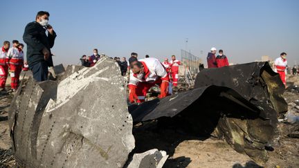 Des officiels explorent l'épave du Boeing 737 ukrainien écrasé près de Téhéran, le 8 janvier 2020. (FATEMEH BAHRAMI / AFP)