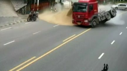 Chine : un poids-lourds rempli de sable évite de justesse d'écraser un motard