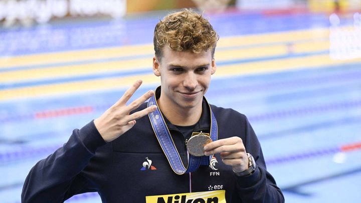 Léon Marchand, avec sa troisième médaille d'or autour du cou lors des Mondiaux de Fukuoka (Japon), le 27 juillet 2023. (HIROKI KAWAGUCHI / AFP)