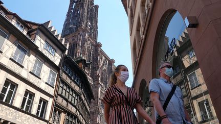 Deux personnes se baladent dans le centre de Strasbourg, le 21 mai, à proximité de la cathédrale. (FRANCK DELHOMME / MAXPPP)