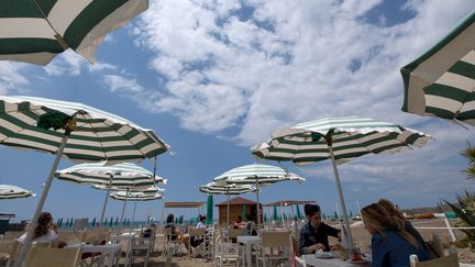 Des touristes mangeant au restaurant sur la plage privée de Fregene, près de Rome, le 30 mai 2020. (TIZIANA FABI / AFP)