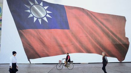 Passers-by in front of the Taiwanese flag, January 13, 2024, voting day on the island.  (SAM YEH / AFP)