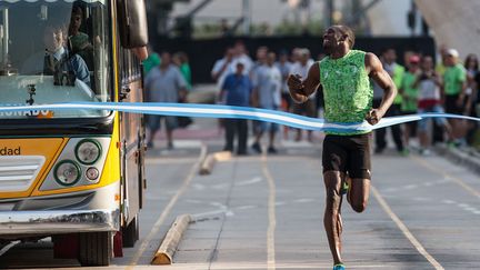 Le coureur jama&Iuml;cain Usain Bolt franchit la ligne d'arriv&eacute;e apr&egrave;s avoir battu un bus &agrave; la course &agrave; Buenos Aires (Argentine), le 14 d&eacute;cembre 2013. (MARTIN ZABALA / CHINE NOUVELLE / SIPA)