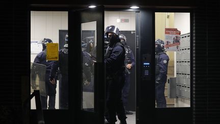 Des policiers entrent dans un immeuble de Villeneuve-la-Garenne (Hauts-de-Seine) lors d'échaufourées avec des habitants, mardi 21 avril. (GEOFFROY VAN DER HASSELT / AFP)