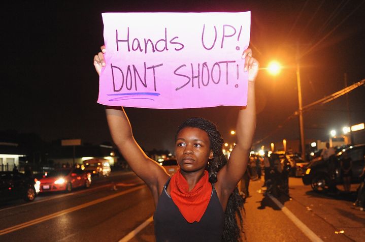 Une manifestante porte une pancarte pacifiste, &agrave; Ferguson (Missouri), aux Etats-Unis, le 17 ao&ucirc;t 2014. (MICHAEL B THOMAS / AFP)