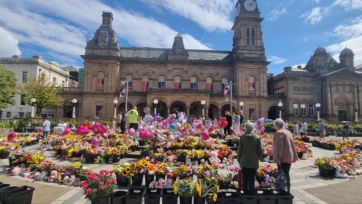 Les habitants de Southport déposent des fleurs devant l'hôtel de ville pour rendre hommage aux trois fillettes tuées. (MARION FERRERE / RADIO FRANCE)