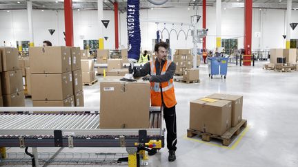 Un employé de l'usine Amazon, à Boves, près d'Amiens, durant la visite du président Emmanuel Macron, le 3 octobre 2017. (YOAN VALAT / POOL)