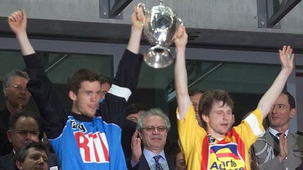 Le capitaine nantais Mickael Landreau (à gauche) et le capitaine calaisien Réginald Becque brandissent la Coupe de France, le 7 mai 2000 au Stade de France, à Saint-Denis. (FRANCOIS GUILLOT / AFP)