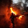 Un pompier devant une voiture incendiée lors de la manifestation des "gilets jaunes" à Paris, le 1er décembre 2018. (ABDULMONAM EASSA / AFP)