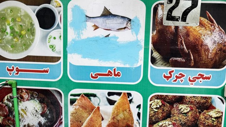 L'image d'un poisson censuré sur le menu d'un restaurant, à Lashkar Gah, dans la province de Helmand, en afghanistan  (le 26 aout 2024) (WAKIL KOHSAR / AFP)