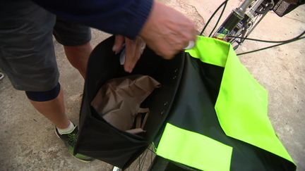 Le "cuissot" charge la nourriture dans son vélo pour aller la distribuer aux sans-abri (France 3 Occitanie)