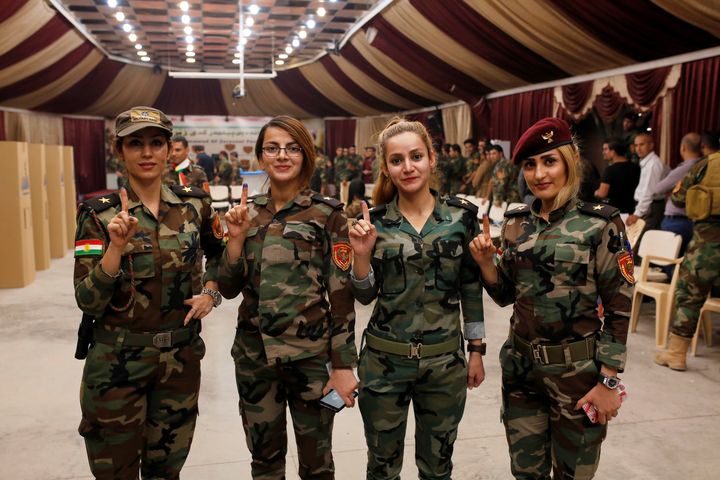 Des combattantes kurdes montrent leur doigt tâché d'encre, signe qu'elles ont voté, le 25 septembre 2017 près d'Erbil (Irak). (YUNUS KELES / ANADOLU AGENCY / AFP)