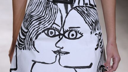 L’art au service de la mode, tels sont le crédo et l’inspiration de Jean Charles de Castelbajac. Son œuvre picturale laisse une trace sur des robes, des jupes, des accessoires, en noir et blanc mais aussi en primaire, les couleurs de la maison. Des visages, un bras, une jambe, apportent une dimension onirique et surréaliste aux silhouettes. Son message se retrouve imprimé en silicone sur des pièces en toile de lin ou peint en or sur ses robes carnets de croquis en feuillet d’organza. La vocation de la maison : embellir toutes les femmes avec de l’art au quotidien. Une garde-robe complète pour une femme Poésic.
 
 
 (FRANCOIS GUILLOT / AFP)