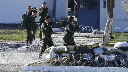 Des soldats ukrainiens emportent des armes, avant de quitter la base de F&eacute;odossia (Crim&eacute;e), dimanche 23 mars 2014.&nbsp; (SHAMIL ZHUMATOV / REUTERS )