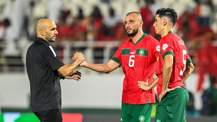 Le sélectionneur marocain Walid Regragui avec ses joueurs Romain Saiss (au centre) et Nayef Aguerd lors du huitième de finale de la CAN, le 30 janvier 2024. (SIA KAMBOU / AFP)