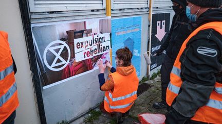 Des activistes d'Extinction Rebellion collent des affiches à Lille (Nord) pour protester contre le mal-logement, le 27 mars 2021.&nbsp; (QUENTIN SAISON / HANS LUCAS / AFP)