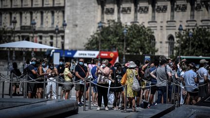 Dans la queue à l'entrée du Louvre, les visiteurs&nbsp;portaient un masque avant même qu'il ne devienne obligatoire, le 6 août 2020. (STEPHANE DE SAKUTIN / AFP)