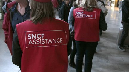 Des employ&eacute;s de la SNCF conseillent des voyageurs &agrave; Paris, lors d'une gr&egrave;ve du 7 octobre 2011. (JACQUES DEMARTHON / AFP)