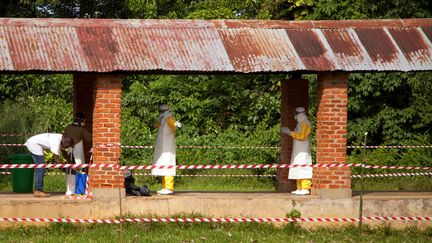 Une équipe médicale est aspergée de chlore à la sortie de l'hôpital de Bikoro, en République démocratique du Congo, où sont soignés des malades d'Ebola, le 12 mai 2018. (MARK NAFTALIN / UNICEF)