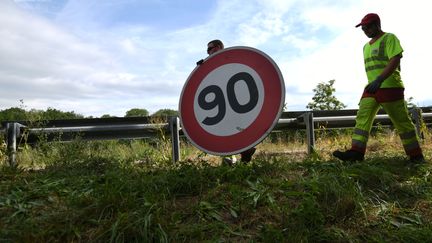 Un employé de la Direction interdépartementale&nbsp;des routes de l'Est remplace un panneau de limite de vitesse, à&nbsp;Wittenheim&nbsp;(Haut-Rhin), le 29 juin 2018. (SEBASTIEN BOZON / AFP)