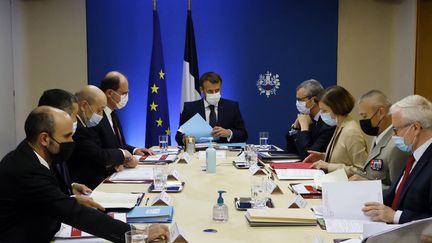 Emmanuel Macron entouré de membres du gouvernement&nbsp;entame une réunion de sécurité nationale pour discuter du logiciel espion Pegasus&nbsp;à l'Elysée à Paris, le 22 juillet 2021. (LUDOVIC MARIN / AFP)