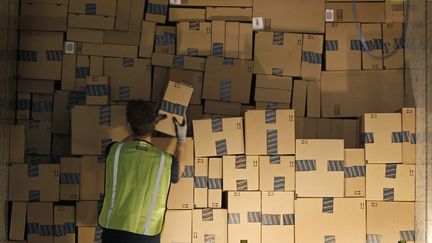 Un employ&eacute; d'Amazon charge un camion de livraison, sur le site de distribution de Phoenix, dans l'Arizona, le 22 novembre 2013. (RALPH FRESO / REUTERS)