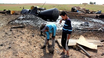 Des enfants jouent dans les d&eacute;combres d'une raffinerie bombard&eacute;e par l'arm&eacute;e am&eacute;ricaine, dans les environs de Tal Abyad (Syrie), le 2 octobre 2014. (AFP)