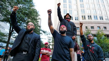 Poings levés, les manifestants ont pacifiquement exprimé leur colère dans le quartier chic de Charlotte, à l'intersection des rues Trade et Tryon.&nbsp; (JASON MICZEK / REUTERS)