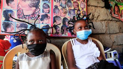 Deux petites filles kenyanes avec la coiffure traditionnelle Bantu Knots, rebaptisée "corona" par le coiffeur d'un salon du bidonville de Kibera à Nairobi, le 29 avril 2020.
 (THOMAS MUKOYA / X90150)