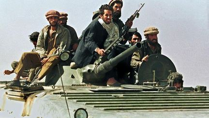 Des partisans du commandant Massoud sur un char foncent vers Kaboul. Ils portent le pakol (béret) traditionnel venant des régions pachtounes. Il a symbolisé pendant l'interminable guerre d'Afghanistan la lutte contre les Soviétiques. (EMMANUEL DUNAND / AFP )