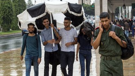 Des jeunes et un militaire dans les rues de la capitale du Maroc, Rabat, le 12 septembre 2018. (FADEL SENNA / AFP)