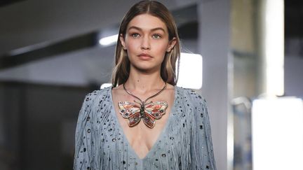 La collection, "prête-à-sortir" de Bottega Veneta, tournée vers la fête, a fait bouger la fashion week au rythme du hip-hop avec ses bijoux, franges et longues robes recouvertes de boutons façon pierres précieuses. Une mode facile à porter : "même les longues robes ont l'air de T-shirts", explique Tomas Maier, le directeur artistique. Les mannequins semblent habillés simplement, presque à l'utilitaire, s'il n'y avait ces quantités impressionnantes de bijoux et accessoires comme de petits miroirs ronds ou de lourds bracelets et colliers dont l'un en forme d'énorme papillon coloré. Idem pour les hommes, qui ont défilé sur le même podium, accessoires en moins, mais daim, vieux satin ou coton piqué en plus. Détenue par le groupe de luxe français Kering, qui détient aussi Gucci, la maison Bottega Veneta a été fondée en 1966 par Michele Taddei et Renzo Zengiaro.
 (Pixelformula/SIPA)