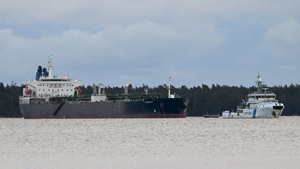 Un navire des garde-côtes finlandais (à droite) surveille le pétrolier "Eagle S" ancré près du port de Kilpilahti, dans le golfe de Finlande, le 30 décembre 2024. (JUSSI NUKARI / LEHTIKUVA / AFP)