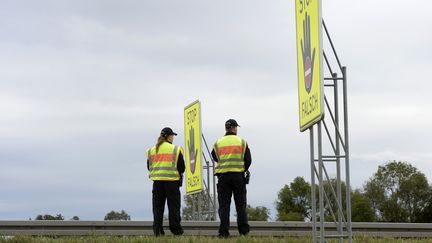 Des policiers attendent pr&egrave;s d'une bretelle d'autoroute, pr&egrave;s de Passau. (CHRISTOF STACHE / AFP)