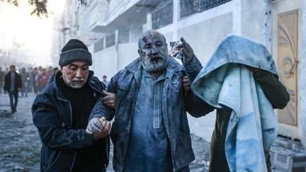 Des Palestiniens aident un homme blessé lors d'un bombardement israélien à Rafah, dans le sud de la bande de Gaza, le 3 décembre 2023. (SAID KHATIB / AFP)