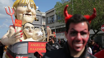 Une statue caricaturant la chanceli&egrave;re allemande, Angela Merkel, et le pr&eacute;sident chypriote, Nicos Anastasiades, est pr&eacute;sent&eacute;e lors d'un carnaval &agrave; Limassol (Chypre), le 17 mars 2013. (YIANNIS KOURTOGLOU / AFP)