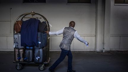 Avant l’embarquement, les porteurs s'affairent à transporter les bagages pendant que les passagers patientent dans un salon de la gare, un verre de champagne ou de vin offert par la compagnie à la main. Puis un majordome les accueille et les accompagne à leurs cabines. Le voyage peut alors commencer. Mais attention, Covid oblige, pour monter dans ce prestigieux train, il faut d’abord avoir fait un test pour prouver sa négativité. &nbsp; &nbsp; &nbsp; (MARCO LONGARI / AFP)