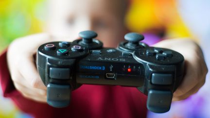 Un enfant tient une manette de Playstation dans ses mains, le 17 octobre 2013 &agrave; Nivelles (Belgique).&nbsp; (FREDERIC SIERAKOWSKI / SIPA)