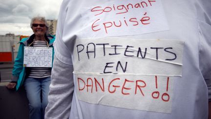 Un slogan écrit sur la blouse d'un infirmier lors de la&nbsp;journée d'action du personnel des urgences, à Toulouse, le 11 juin 2019.&nbsp; (ALAIN PITTON / NURPHOTO)