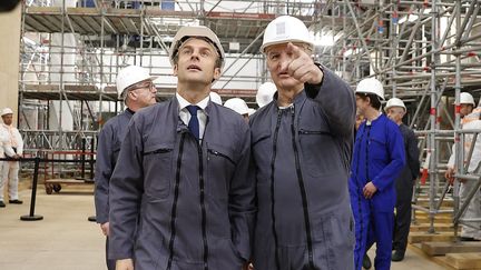 Le président français Emmanuel Macron aux côtés du général Jean-Louis Georgelin, le 15 avril 2022, lors d'une visite sur le chantier de reconstruction de la cathédrale Notre-Dame de Paris. (IAN LANGSDON / AFP)