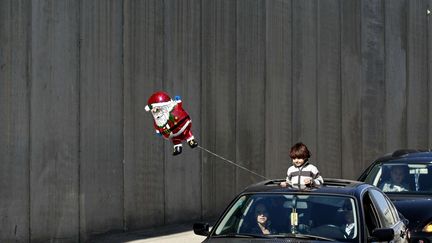 Difficile de ne pas craquer devant ce gar&ccedil;on tenant un ballon &agrave; l'effigie du p&egrave;re No&euml;l, &agrave; Bethl&eacute;em (Cisjordanie), le 24 d&eacute;cembre 2012. (NASSER SHIYOUKHI/AP/SIPA)