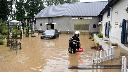 Un pompier intervient dans une rue inondée d'Adé, près de Lourdes (Hautes-Pyrénées), le 3 juin. (LAURENT DARD / AFP)