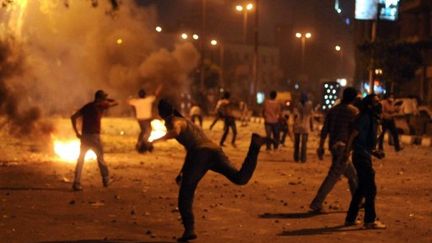 Des manifestants en train de jeter des pierres au Caire contre la police après l'attaque de l'ambassade israélienne (AFP - MOHAMED HOSSAM)